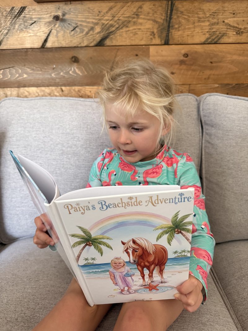 Child on a couch reading her personalized hardcover StorySafari book