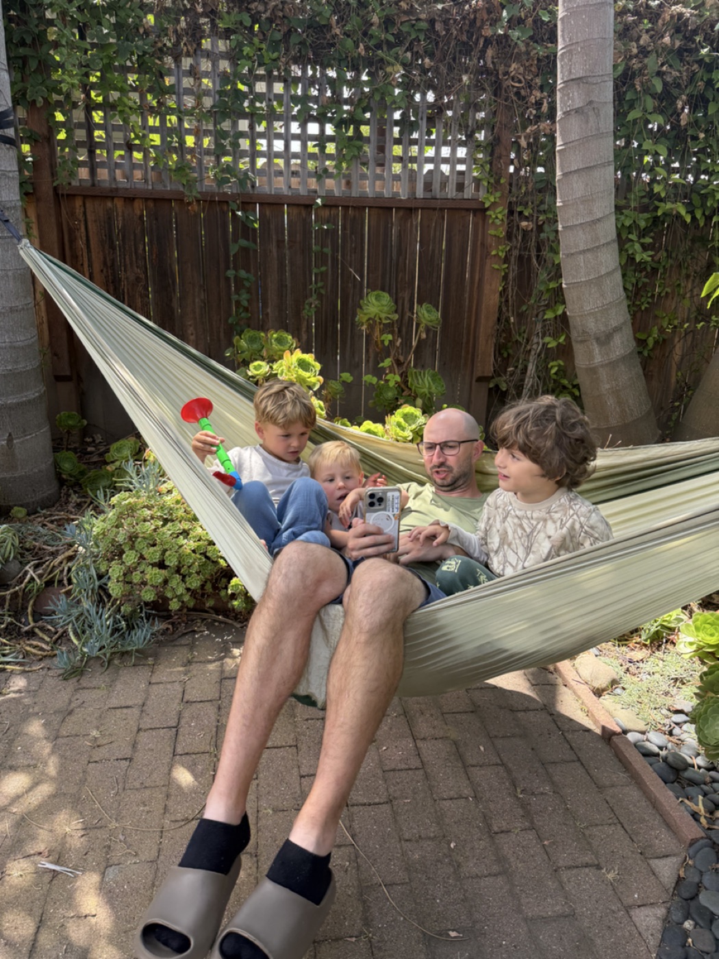 Family reading a StorySafari story together in a backyard hammock