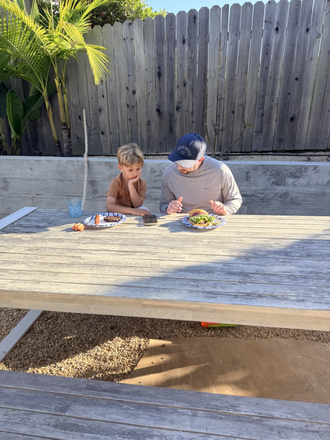 Parent and child viewing a StorySafari story on a phone at a patio table